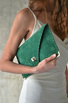 The perfect bag for all day needs, evening entertainment and going to a party.This adorable bag is handmade out of a beautiful high quality, emerald green suede Italian leather.It is hand stitched with green waxed thread. The color of the waxed thread can change upon request.The interior is fully lined with beige leatherette.The clutch closes with a metal twisted clasp and has metal endings, available in silver and gold color. The pictures show the clutch with gold metal hardware.Dimensions: Hei Luxury Green Clutch With Detachable Strap, Green Leather Clutch For Evening, Green Leather Evening Clutch, Green Leather Rectangular Clutch, Green Rectangular Leather Clutch, Chic Green Pouch Evening Bag, Soft Leather Rectangular Clutch For Party, Chic Green Clutch Evening Bag, Elegant Green Envelope Clutch