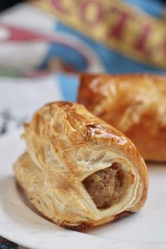 two pastries sitting on top of a white plate next to an open pastry wrapper