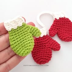 two crocheted mittens are being held in someone's hand