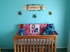 a baby crib with stuffed animals and a surfboard on the wall