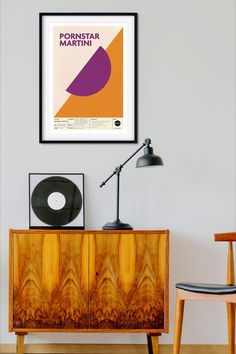 a poster hangs on the wall next to a sideboard with a record in it