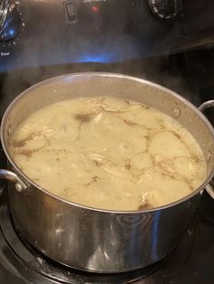 a pot filled with food sitting on top of a stove next to a burner