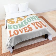 a bed with a comforter that says someone loves you