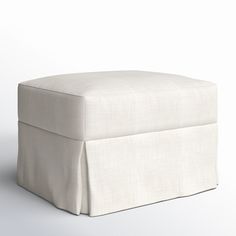 a white footstool with a pleated cover on it's sides and bottom