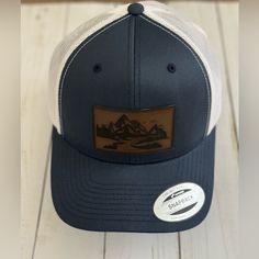 Enjoy This New Trucker Hat, With A Leather Patch Of The Cascade Mountains. Casual White Hat For Camping, White Snapback Hat With Leather Patch, Casual Six-panel Trucker Hat With Leather Patch, Outdoor Six-panel Trucker Hat With Leather Patch, Trucker Style 5-panel Baseball Cap With Logo Patch, Adjustable 5-panel Trucker Hat With Leather Patch, Cascade Mountains, Leather Patches, Navy And White