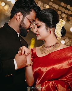 a man and woman standing next to each other with lights in the back ground behind them