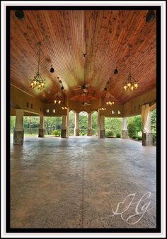 an empty dance floor with chandeliers hanging from the ceiling