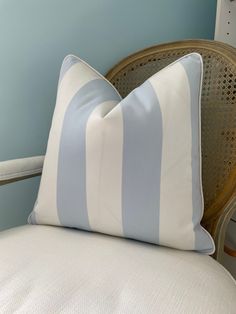 a blue and white striped pillow sitting on top of a chair