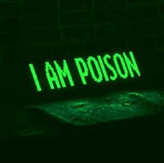 the word i am poison is projected in green light