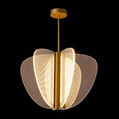 a modern light fixture in the shape of an apple on a black background with gold accents