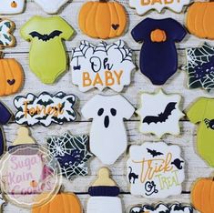 decorated cookies are arranged on a table for baby's first halloween party, including bats, ghostes and pumpkins