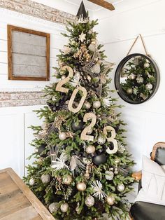 a decorated christmas tree in a living room with ornaments on the top and numbers on the bottom