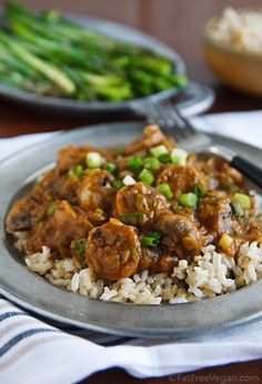 a plate full of rice and meat with asparagus