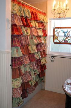 a shower curtain made out of colorful fabric on the side of a bath room wall