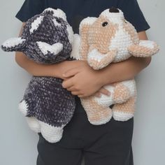 a little boy holding two stuffed animals in his hands