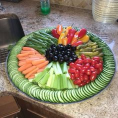 a platter filled with vegetables on top of a kitchen counter