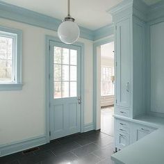 an empty kitchen with light blue cabinets and tile flooring in the middle of it