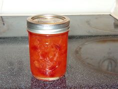 a jar filled with red liquid sitting on top of a counter