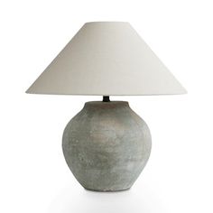 a lamp that is on top of a white surface with a light shade over it