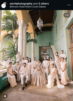 a group of people posing for a photo in front of a building with columns and pillars