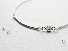 "Sterling silver ultra-skinny tube bracelet or anklet with sparkling bezel-set CZ stone (cubic zirconia). Slim and sleek, delicate yet sturdy, this is the perfect simple minimalist everyday jewelry. Made in the USA. Made to Order. DETAILS Sterling Silver Tube: 25mm CZ Stone: 4mm * Made entirely of Sterling Silver materials * High quality Cubic Zirconia Stone * Handcrafted with love & care * This is a Custom Made Item * Complimentary gift wrapping (See FAQ for details) BRACELET/ ANKLET SIZING Silver Sterling Bracelet With Single Diamond, Minimalist Sterling Silver Round Diamond Bracelet, Minimalist Silver Bracelet With Single Diamond, Minimalist Round Sterling Silver Diamond Bracelet, Minimalist White Sterling Silver Jubilee Bracelet, Minimalist Adjustable Sterling Silver Diamond Bracelet, Silver Diamond Bracelet With Bezel Setting In Sterling Silver, Minimalist Adjustable Silver Diamond Bracelet, Adjustable Silver Minimalist Diamond Bracelet