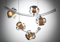 an unusual light fixture is hanging from a metal bar with glass balls and rings on it