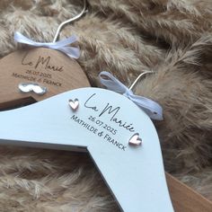 two wooden hangers with names and hearts on them