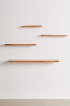 three wooden shelves on the wall with one shelf above them