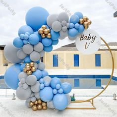 a bunch of balloons that are in front of a pool with a baby sign on it