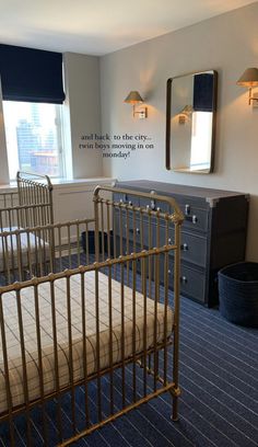 there is a crib in the room with two mirrors on the wall above it