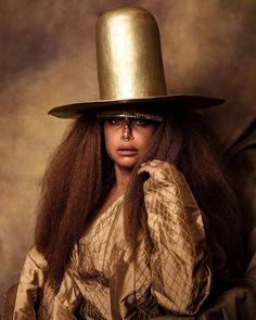 a woman with long hair wearing a gold hat