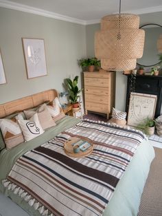 a bed room with a neatly made bed and some pictures on the wall above it