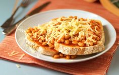 a white plate topped with bread covered in beans and cheese