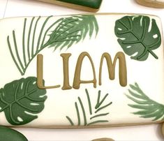 a decorated cookie with the word i am written on it and palm leaves around it