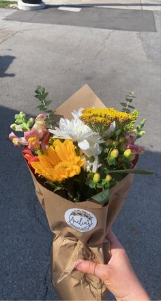 a person holding a bouquet of flowers in their hand