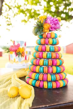 a stack of macaroni and cheese on a table with flowers in the background