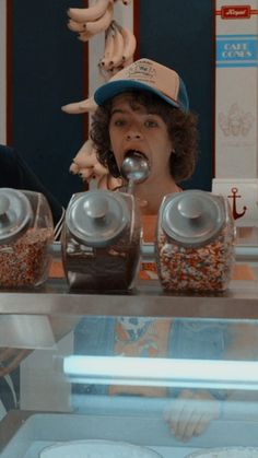 a man and woman standing in front of a display case with food items on it