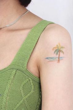 a woman with a small palm tree tattoo on her left upper arm and right lower arm