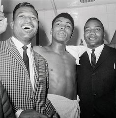 three men standing next to each other in a bathroom