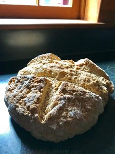 a piece of bread sitting on top of a table next to a window sill