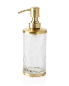 a glass soap dispenser with gold trimming and a metal faucet