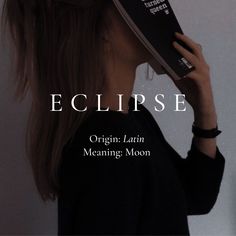 a woman holding up a book to her face with the title eclipse written on it