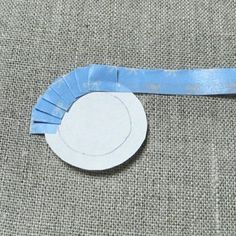 a piece of blue tape with a white circle on it sitting on a gray surface