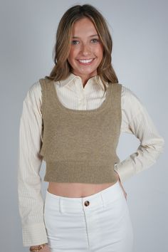 Experience effortless style with the Guinevere Layered Sweater. This unique piece features a cropped sweater vest layered over a cropped pin stripe long sleeve collared shirt for a chic and trendy look. Take your wardrobe to the next level with this fashion-forward statement piece! Size + Fit Anna is 6'1" and wearing a size Small Content + Care 100% Wool Contrast: 100% Cotton Dry Clean Only Casual Cropped Sweater For Layering, Fall Layering Cropped Crop Top, Trendy Cropped Sweater For Layering, Trendy Cropped Sweater Vest For Fall, Casual Cropped Vest For Work, Fitted Cropped Sweater Vest, Versatile Cropped Sweater For Spring, Trendy Cropped Sweater Vest For Spring, Chic Cropped Sweater Vest For Fall