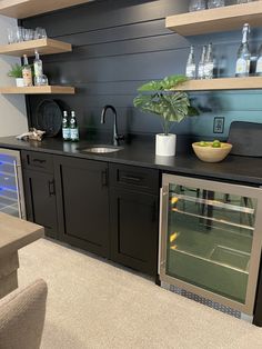 a kitchen with an oven, sink and shelves filled with bottles on top of it