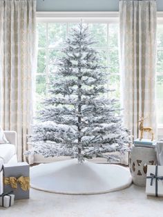 a white christmas tree sitting in front of a window