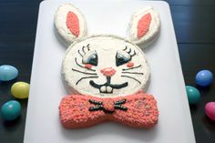 a cake shaped like a rabbit with a bow tie on it's head and ears