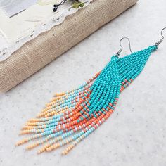 a pair of beaded earrings sitting on top of a table