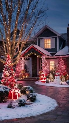 a house decorated for christmas with lights and trees in the front yard, snow on the ground