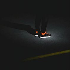 a person standing in the dark with their shoes on